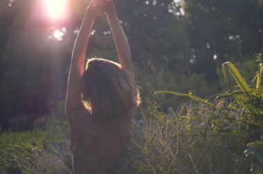 Kadın günbatımı bahçeye sahiptir..