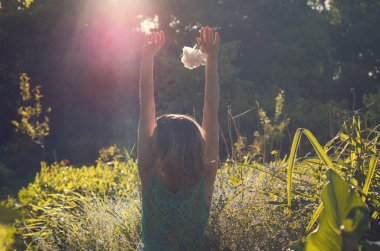 Kadın günbatımı bahçeye sahiptir..