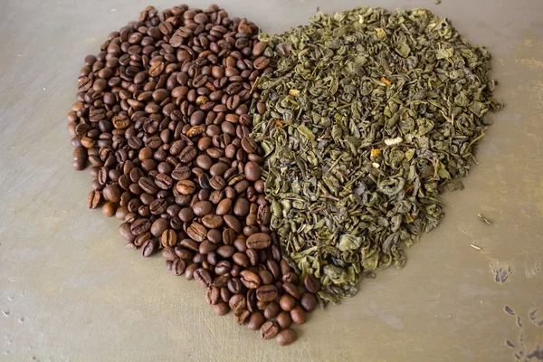 Heart of grains  black coffee and green tea leaves — Stock Photo, Image
