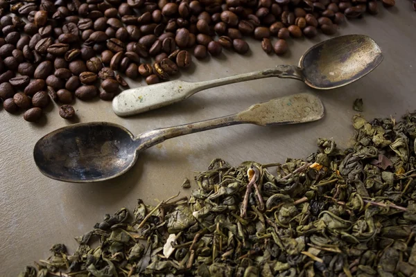 Бобы черного кофе и зеленые чайные листья — стоковое фото