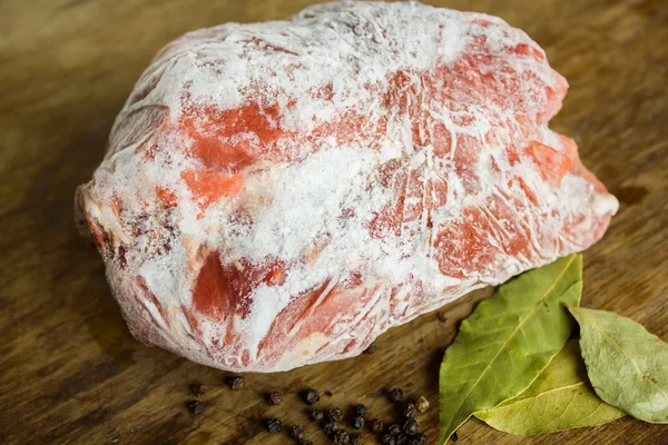 Carne congelada numa mesa de madeira — Fotografia de Stock