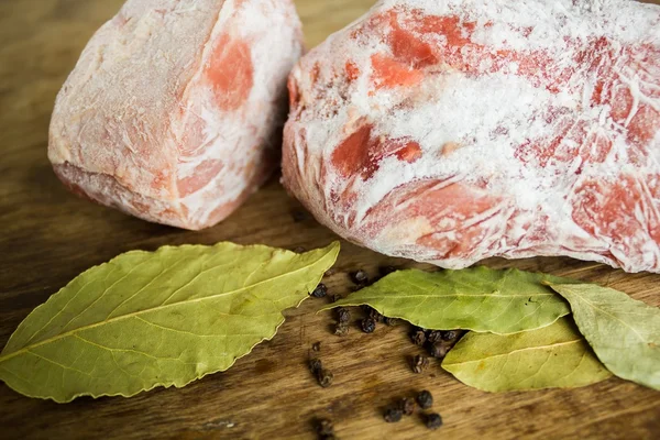 Заморожене м'ясо на дерев'яному столі — стокове фото