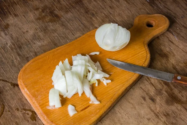 Cebollas en rodajas en una tabla de madera — Foto de Stock