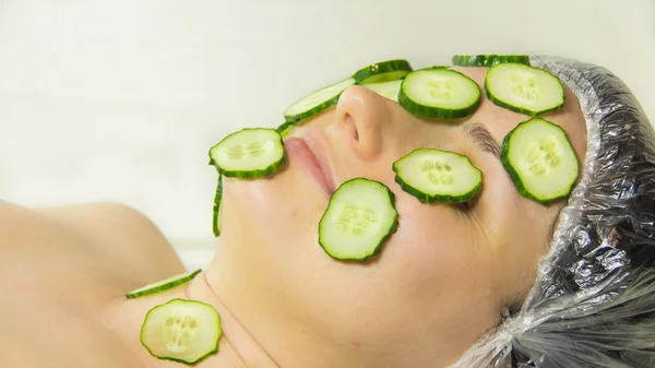 Closeup vrouw op gezicht met komkommer Stockfoto