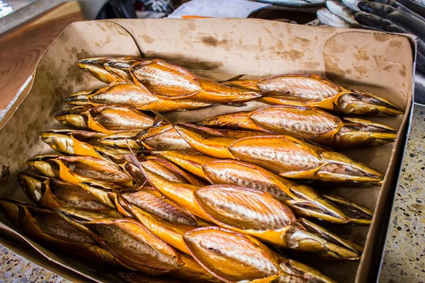 Peixe defumado em tamanhos diferentes que põe em uma mesa — Fotografia de Stock