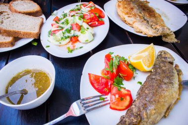 Taze bitki ve limonlu kızarmış balık.