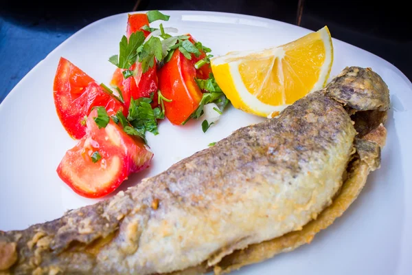 Fried fish with fresh herbs and lemon — Stock Photo, Image