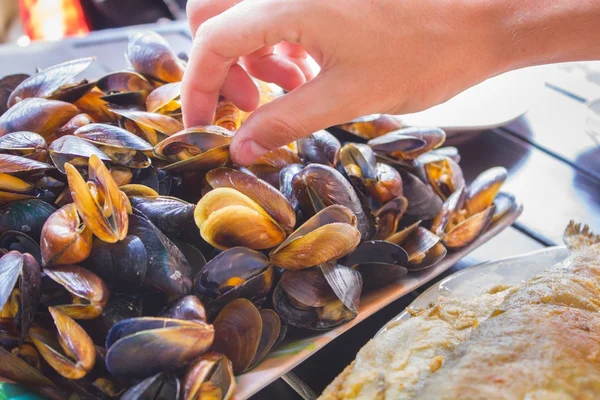 Hombre mano tomar mejillones — Foto de Stock