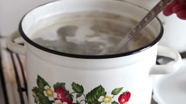 Casserole avec bouillon où la main féminine empêche le bouillon — Video