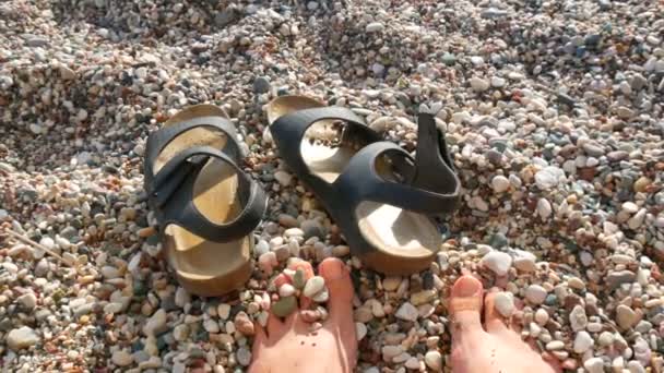 여름 방학 컨셉트인 모래 해변에 있는 암컷 발가락과 가죽 샌들 — 비디오