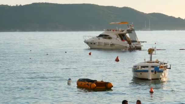 Becici, Karadağ - 27 Ağustos 2020: Deniz kıyısında küçük turistik yat ve teknelerin yanında güzel bir tatil — Stok video