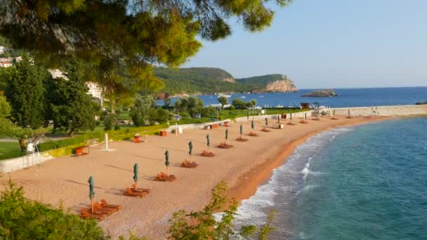 St. Stephens Island, Černá Hora. Slavný ostrov hotelů pro celebrity a bohaté lidi na světě. Krásná čistá pláž s lehátky a slunečníky na břehu Jaderského moře — Stock video