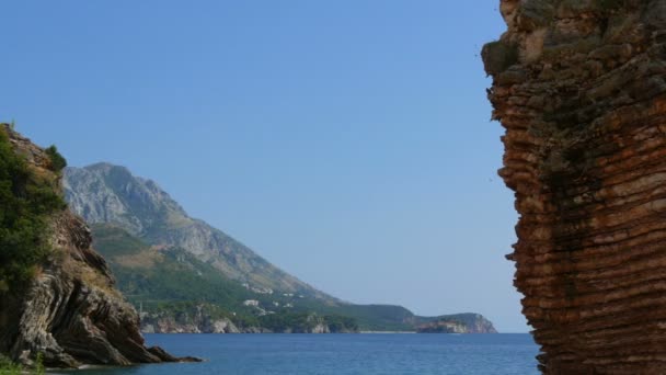 На тлі чистого бірюзового моря, що в затоці Котор (Чорногорія), мальовничі скелі й гори. Прекрасна незаймана природа — стокове відео