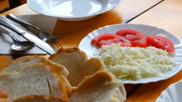 Menú vegetariano, ensalada de col y rodajas de tomate en la mesa del comedor — Vídeos de Stock