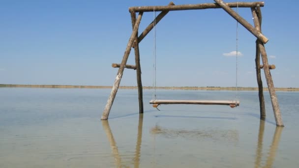 Samotny drewniany huśtawka na wodzie jest malowniczo położony na słonym jeziorze, rekreacja relaks koncepcja — Wideo stockowe