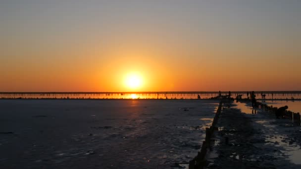 İnanılmaz kırmızı gün batımı. Tuz gölünde kocaman yuvarlak bir güneş. — Stok video