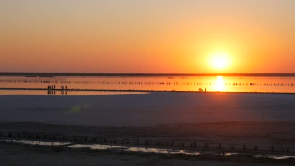İnanılmaz kırmızı gün batımı. Tuz gölünde kocaman yuvarlak bir güneş. — Stok video