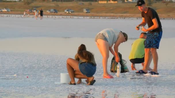 Schastlivtsevo, Ucraina - 6 august 2020: Oamenii minează sare pe crusta sărată albă pe fabrica de extracție a lacului sărat Sivash din regiunea Kherson, Ucraina — Videoclip de stoc