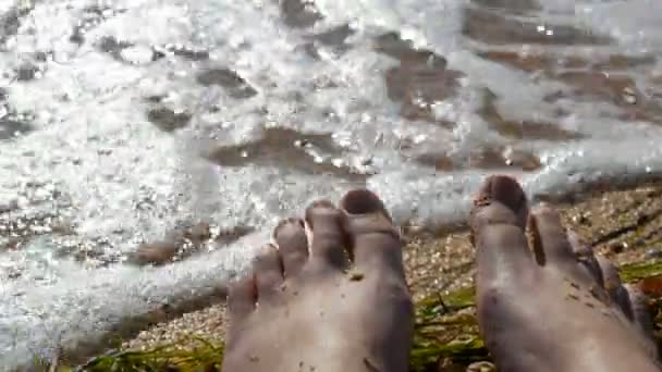 Los pies femeninos, los dedos de los pies en la playa de concha marina, el mar y las olas. Concepto de relajación, vacaciones de verano. POV — Vídeo de stock