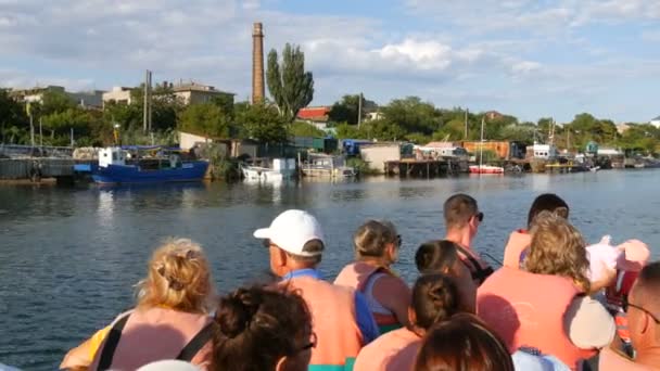 Genichesk, Ucrania - 2 de agosto de 2020: Un guía turístico en un barco de recreo cuenta historias a los turistas que llevan chalecos salvavidas. Excursión al lago Sivash — Vídeos de Stock