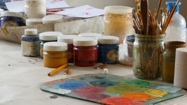 Petrykovka, Ukraine - October 14, 2020: palette with different paint colors, different brushes and paints for painting on the table in the artists studio — Stock Video