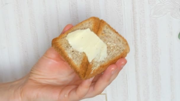 Tangan wanita menyebarkan mentega dengan pisau meja pada roti panggang panggang, pandangan dekat, menempatkan potongan tipis sosis salami. Pagi sarapan — Stok Video