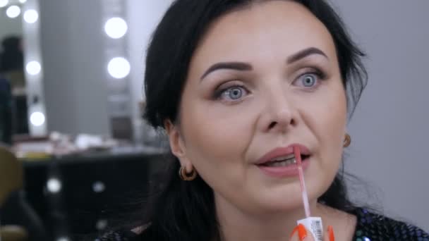 Ung vacker praktfull kvinna framför spegeln applicerar ansiktsmakeup och läppstift — Stockvideo