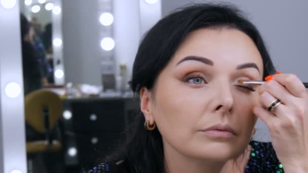 Ung vacker praktfull kvinna framför spegeln applicerar ansikte och ögonmakeup med en speciell borste — Stockvideo