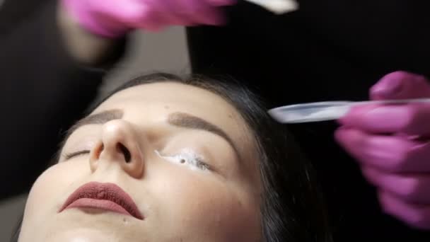 Moderna procedura di laminazione della guarigione delle ciglia in un salone di bellezza professionale. Il maestro applica una speciale schiuma detergente agli occhi prima della procedura di arricciatura delle ciglia. — Video Stock