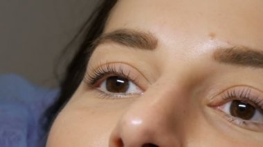 Kirpik kıvırma işleminden önce profesyonel bir güzellik salonunda modern kirpik kirpikleme prosedüründen önceki genç bir kızın yüzü. Siyah rujlu makyajsız bir kadın portresi.