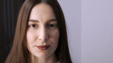 Kirpik kıvırma işleminden önce profesyonel bir güzellik salonunda modern kirpik kirpikleme prosedüründen önceki genç bir kızın yüzü. Siyah rujlu makyajsız bir kadın portresi.