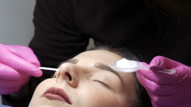 Modernes Wimpernheilverfahren in einem professionellen Schönheitssalon. Der Meister trägt vor dem Wimpernkräuseln einen speziellen Reinigungsschaum auf die Augen auf — Stockvideo