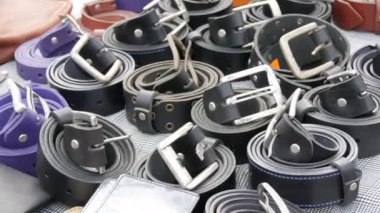 Açık hava tezgahında siyah ve mavi deri kemerler.