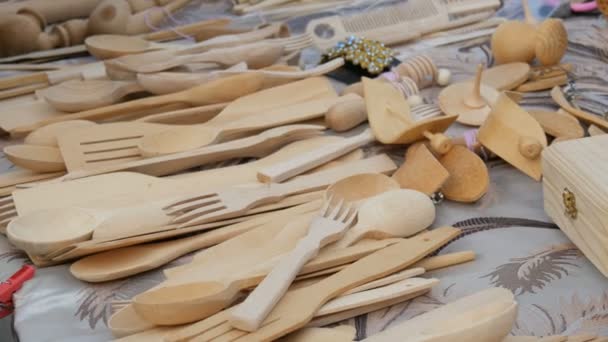 Různé dřevěné lžíce a vidličky na veletrhu. Dřevěné kuchyňské spotřebiče na pultu trhu — Stock video