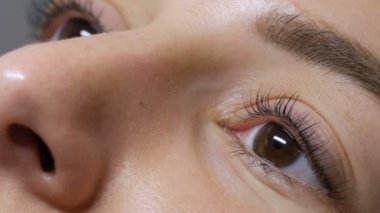 Kirpik kıvırma işleminden önce profesyonel bir güzellik salonunda modern kirpik kirpikleme prosedüründen önceki genç bir kızın yüzü. Siyah rujlu makyajsız bir kadın portresi.