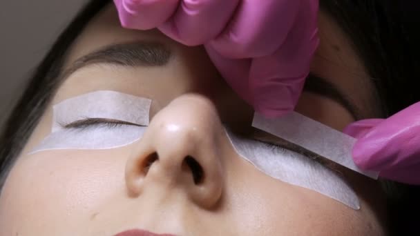 Moderne wimper lamineren procedure in een professionele schoonheidssalon. De master plakt speciale zelfklevende vlekken op de ogen voor de wimper curling procedure — Stockvideo