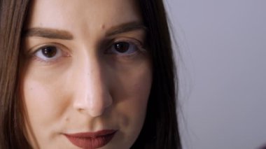 Kirpik kıvırma işleminden önce profesyonel bir güzellik salonunda modern kirpik kirpikleme prosedüründen önceki genç bir kızın yüzü. Siyah rujlu makyajsız bir kadın portresi.