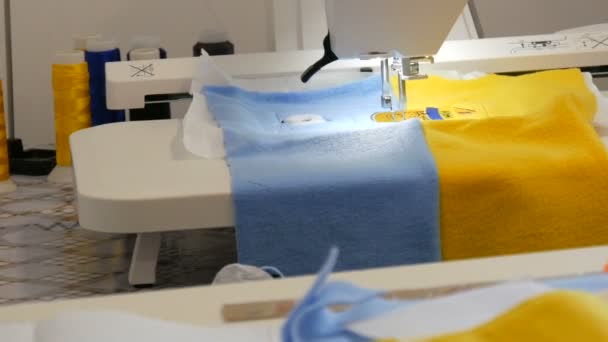 L'ago della macchina per cucire per ricamo fa un ornamento su un pezzo di tessuto azzurro e giallo. Speciale macchina da cucire per ricamo al lavoro. Macchina da cucire programmabile — Video Stock