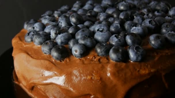 Close up widok ciasta czekoladowego brownie z lukrem kakaowym i jagody na stylowe czarne tło w niskim kluczem — Wideo stockowe