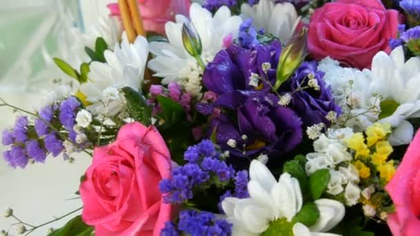 Piękny stylowy bukiet różnych wielobarwnych kwiatów stokrotek, róż, suszonych kwiatów. Uroczysty bukiet ślubny z białych, różowych, niebieskich, fioletowych, żółtych kwiatów — Wideo stockowe