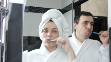 Genç çiftler dişlerini banyoda fırçalıyorlar. Karı koca ya da erkek arkadaş ya da kız arkadaş aynaya bakıp birlikte banyo yapıyorlar. Ağız temizliği, sabahları sağlıklı dişler.