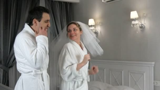 Funny married young newlywed couple dancing merrily in the hotel