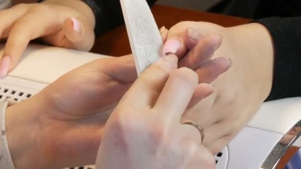 マニキュア師は特別なネイルファイルで爪の形状をファイルします。 — ストック動画