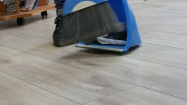 Kuaför salonundaki saç kesiminin sonu. Kesik saç bir süpürge ve kepçe ile süpürülür.