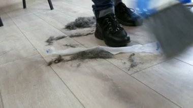 Kuaför salonundaki saç kesiminin sonu. Kesik saç bir süpürge ve kepçe ile süpürülür.