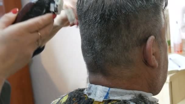 29 Januari 2021: Pencukur rambut khusus atau pemangkas memotong rambut di kepala. Seorang pria tua berambut abu-abu yang memotong rambut di salon tata rambut. — Stok Video