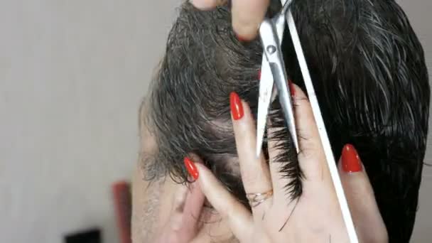 Cabeleireiro mulher mãos com manicure vermelho cortar o cabelo com tesoura na cabeça. Um homem idoso de cabelos grisalhos que corta o cabelo num salão de cabeleireiro — Vídeo de Stock