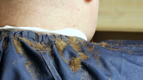 Kurzgeschorene Haare eines rothaarigen Mannes auf der Schulter im Friseursalon — Stockvideo