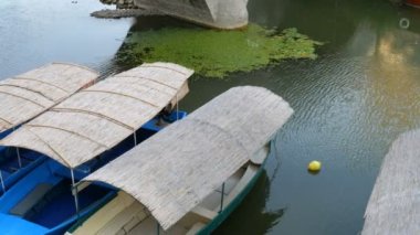 Turkuazın arka planında üç boş zevk ya da balıkçı teknesi bir tatlı su nehri ya da gölün şeffaf sularıdır.