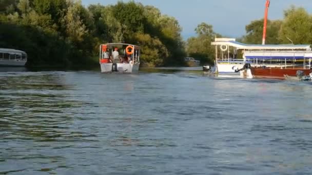 Virpazar, Μαυροβούνιο - 25 Αυγούστου 2020: σκάφη αναψυχής ή αλιείας με τουρίστες στο φόντο του τυρκουάζ διάφανα καθαρά νερά ενός ποταμού γλυκού νερού ή της λίμνης — Αρχείο Βίντεο